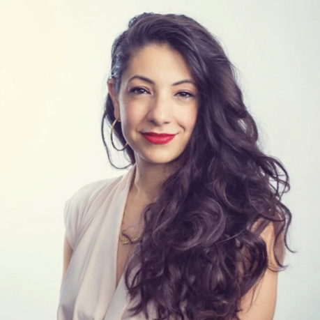 Woman with long brown hair and red lipstick smiling into camera.